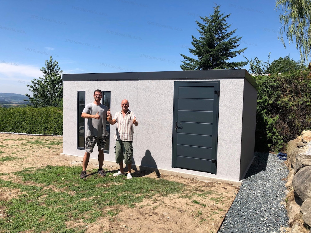 Zadowolony klient przed montowanym domkiem ogrodowym w jasnoszarym tynku