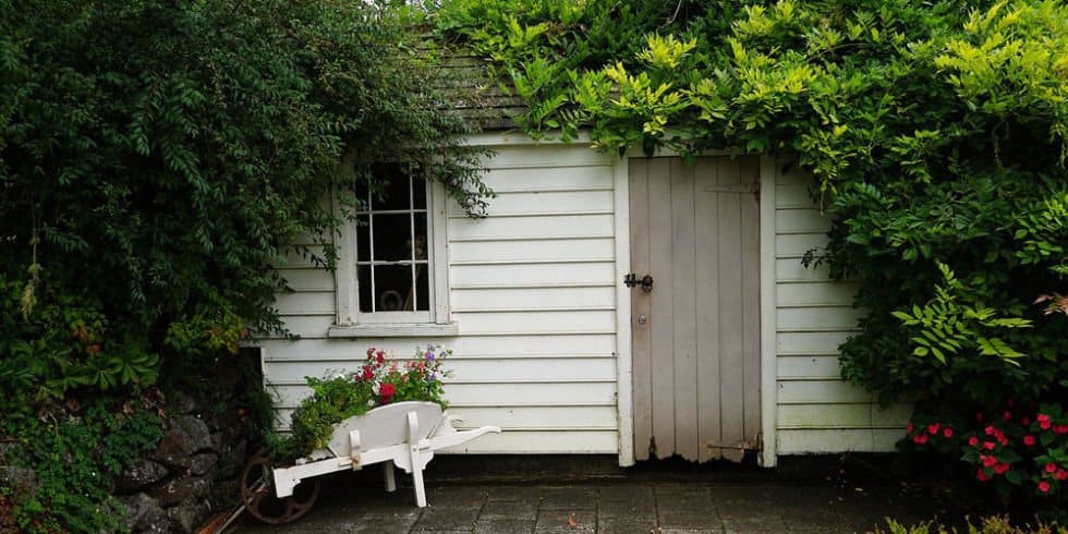 Drewniany domek ogrodowy na narzędzia w białym kolorze