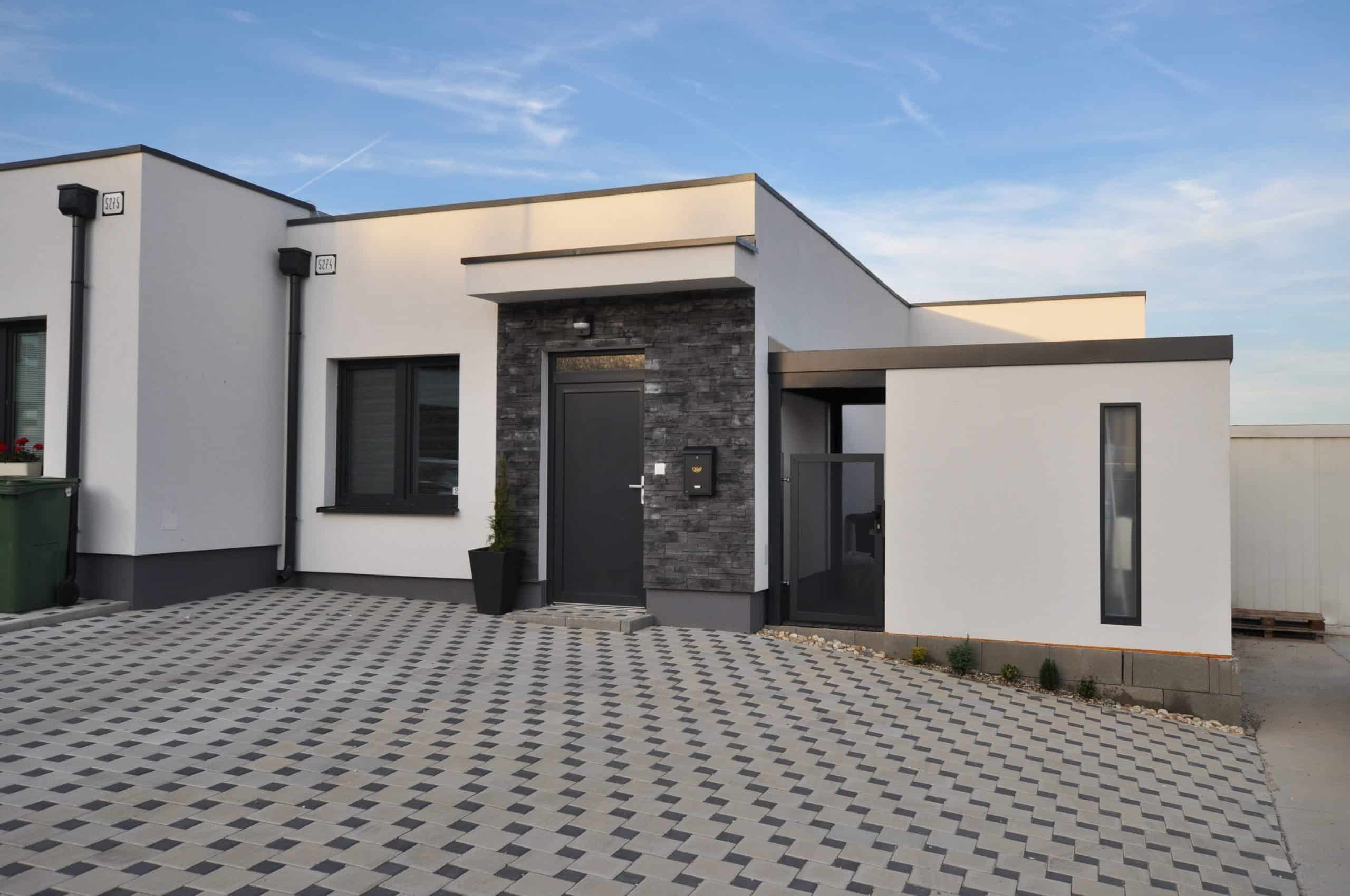 Domek ogrodowy w białym tynku przy domu