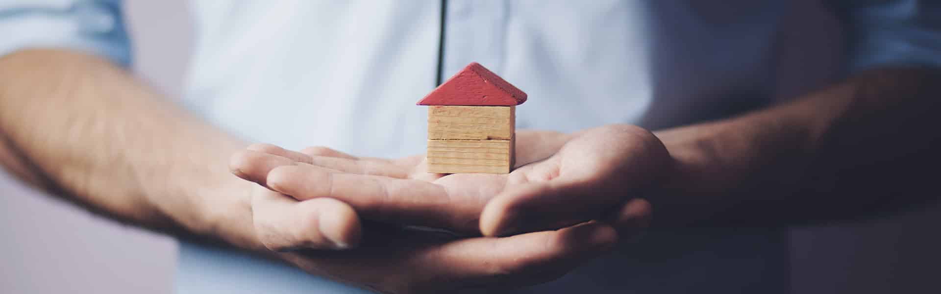 Drewniany dom na dłoni
