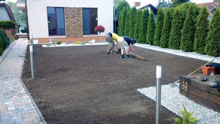 Dw&oacute;ch pan&oacute;w wyr&oacute;wnuje ziemię na działce