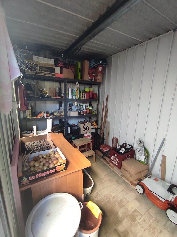 Regál vo vnútri záhradného domčeka so záhradnými potrebami