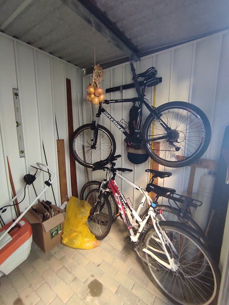 Bicykel opretý o stenu motnovaného záhradného domčeka