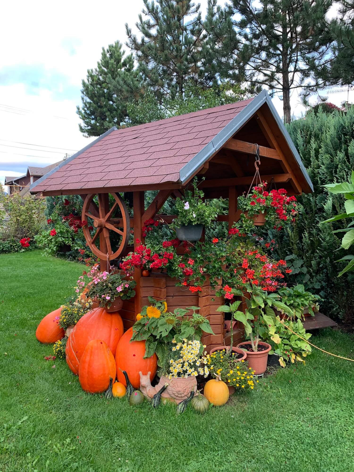 Dekoracja z dyni z kwiatami przy studzience po prawej stronie