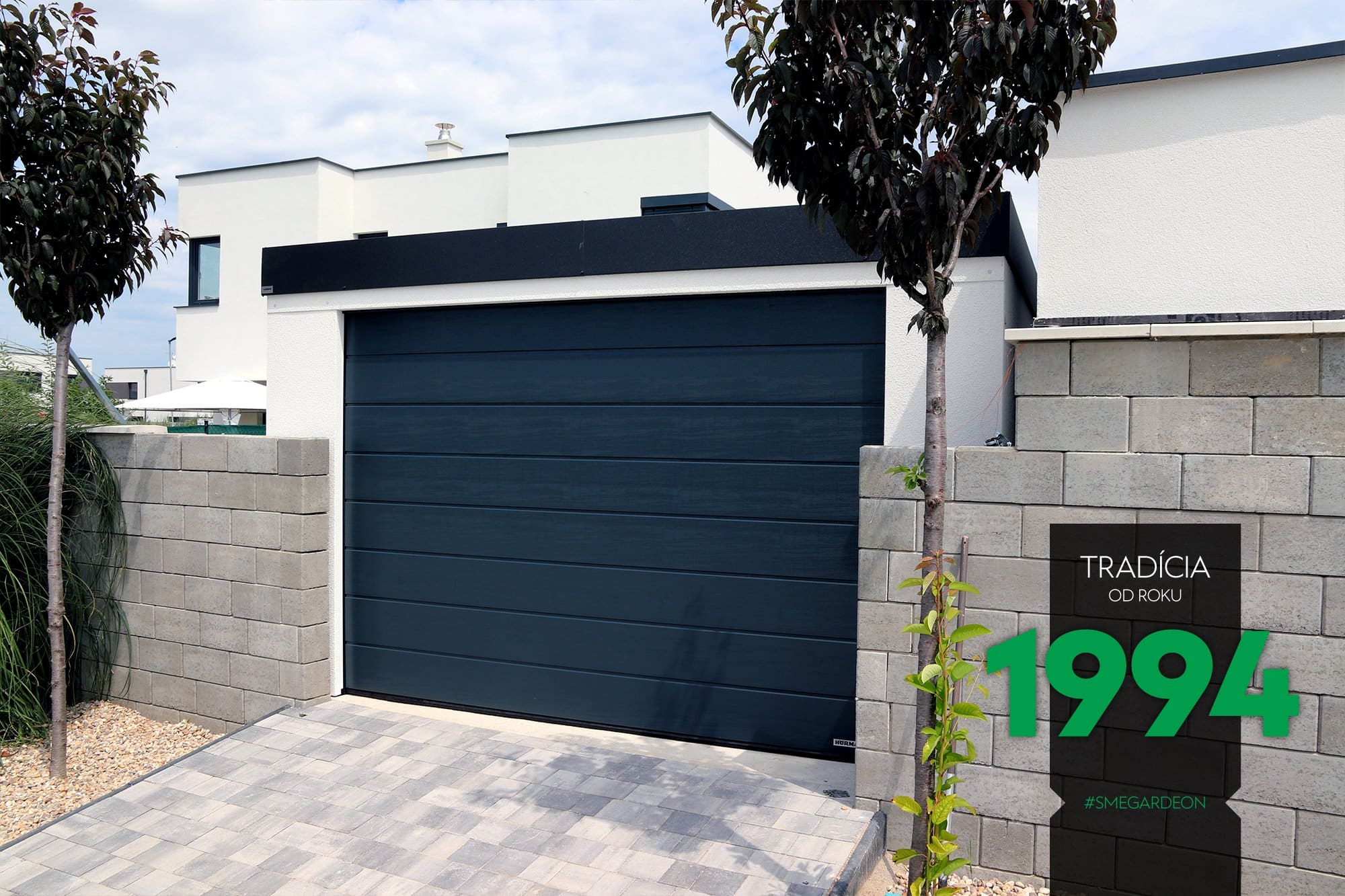 Garaż na jeden samoch&oacute;d przy ceglanym płocie z prawej strony