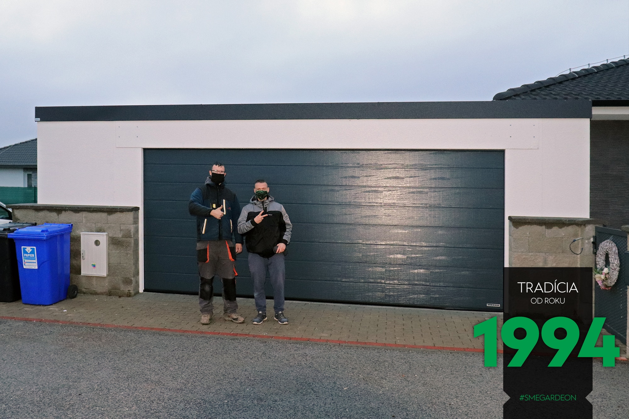 Montážnici pred garážou pre dve autá