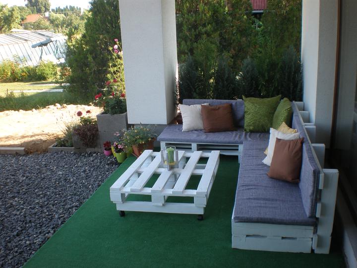 Bielo sivé posedenie z paliet pod prístreškom