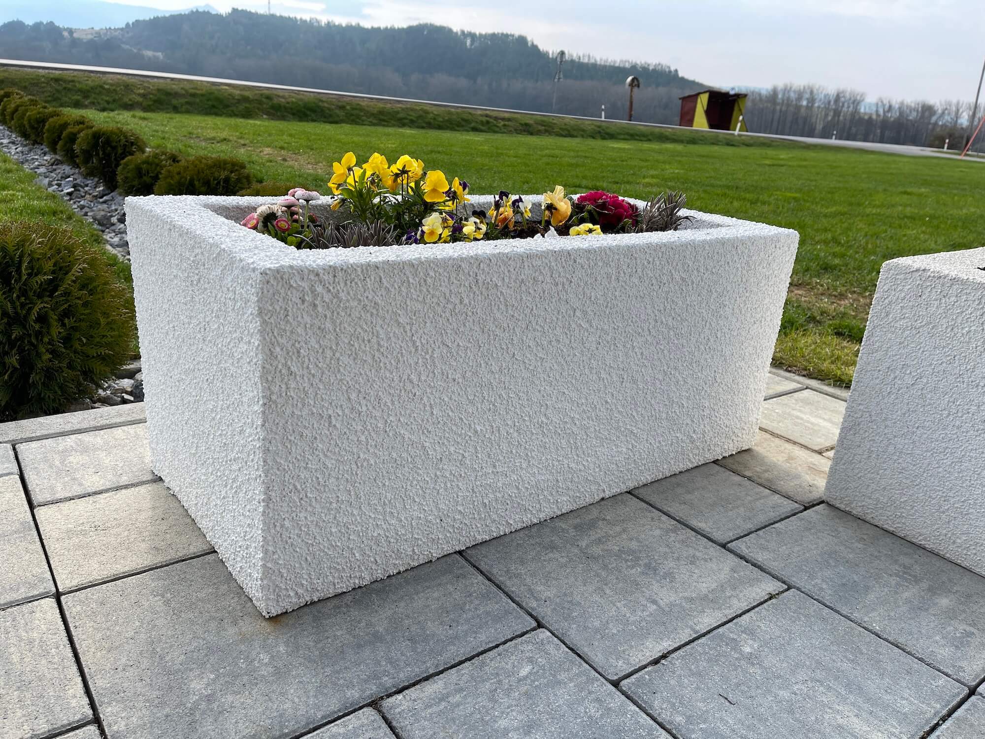 Bílý vyvýšený záhon na terase.