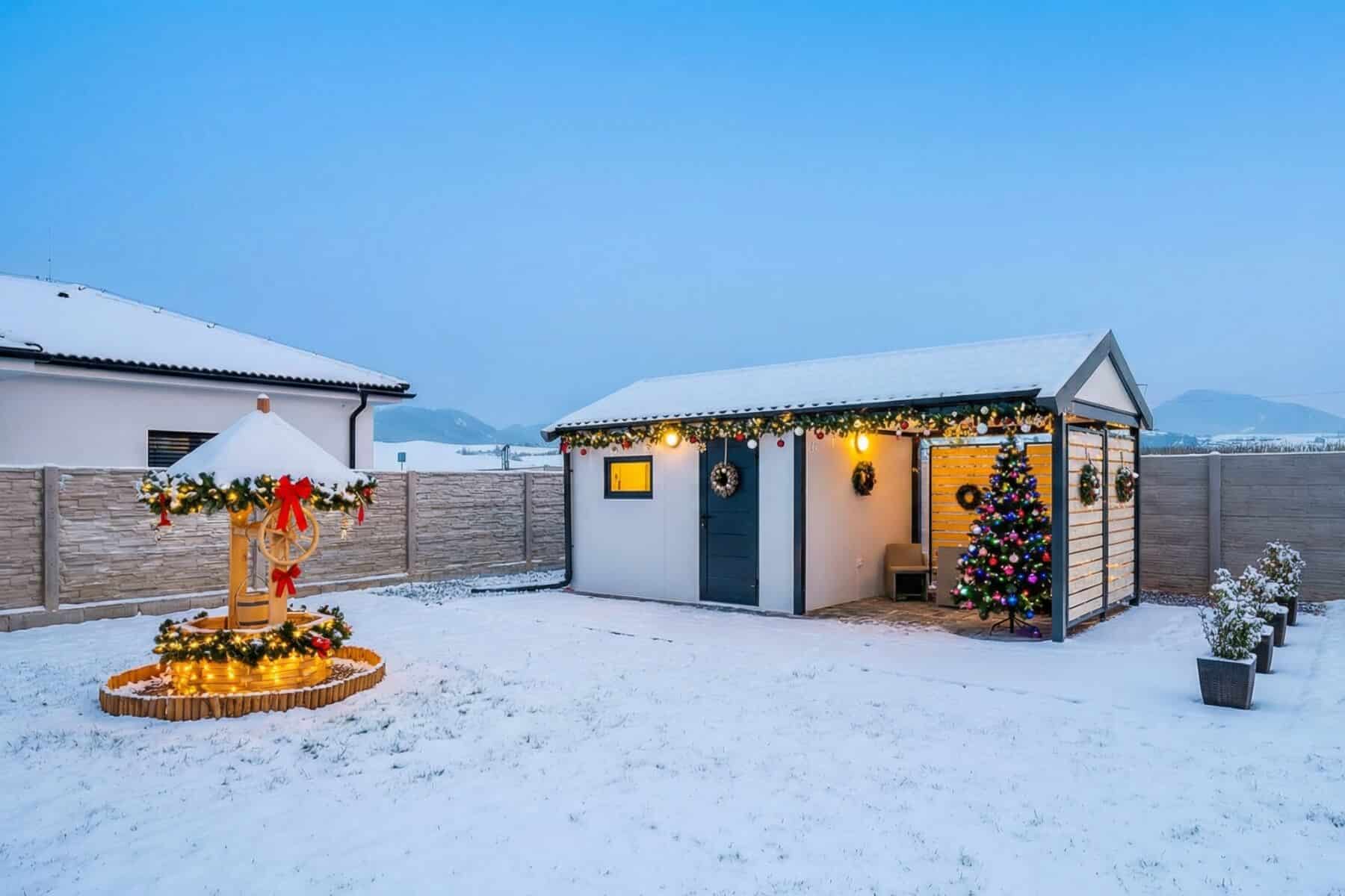 Vánočně vyzdobený zahradní domek s přístřeškem.