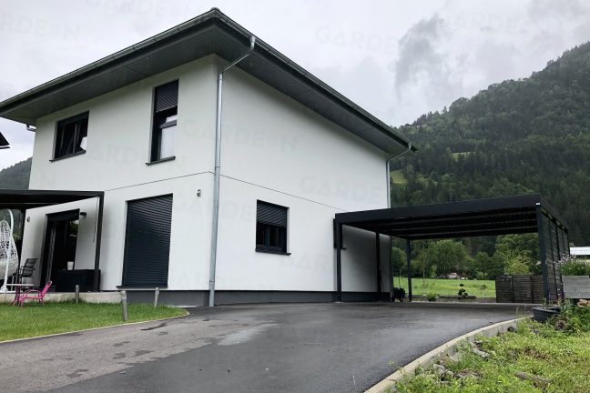 Moderný prístrešok pri bielom rodinnom dome