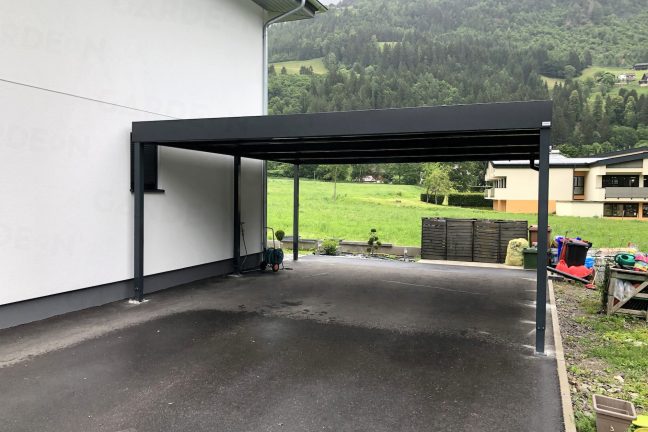 Antracitový prístrešok pri bielom rodinnom dome