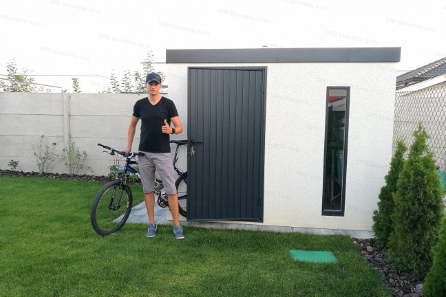 Spokojný zákazník pred montovaným záhradným domčekom GARDEON v bielej omietke