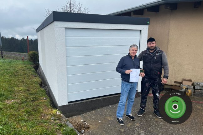 Spokojený zákazník s montážníkem před novou garáží GARDEON