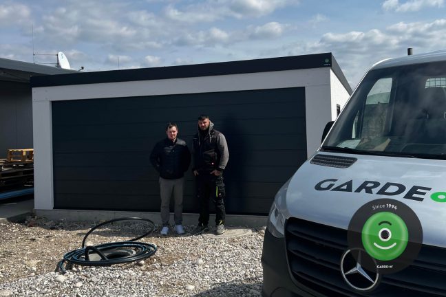 Spokojený zákazník s montážníkem před novou garáží GARDEON