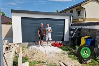 Spokojený zákazník s montážníkem před garáží