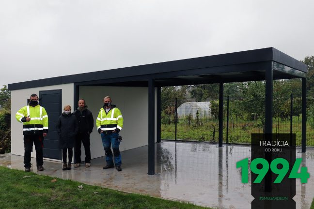 Spokojný zákazníci s montážnikmi pri záhradnom domčeku s prísreškom