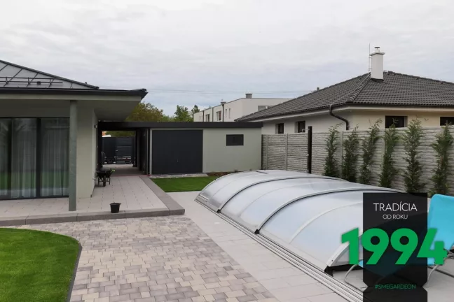 Dvojgaráž s přístřeškem a garážovými vraty na zadní straně.