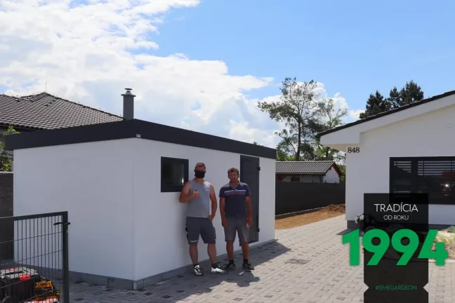 Spokojený zákazník s montážníkem před zahradním domkem