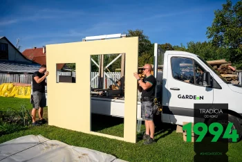 Montážníci vykládají části stavby z dodávky