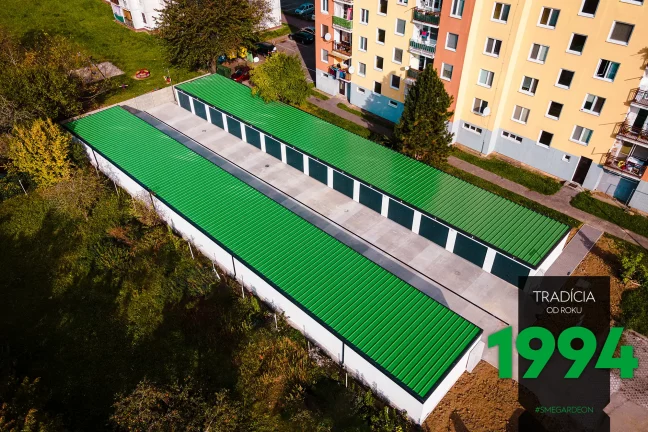 Řadové garáže v bílé omítce se zelenou střechou