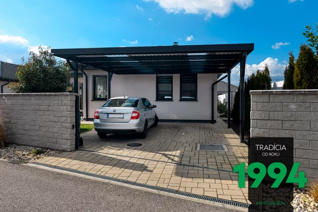 Auto pod přístřeškem za hliníkovou bránou