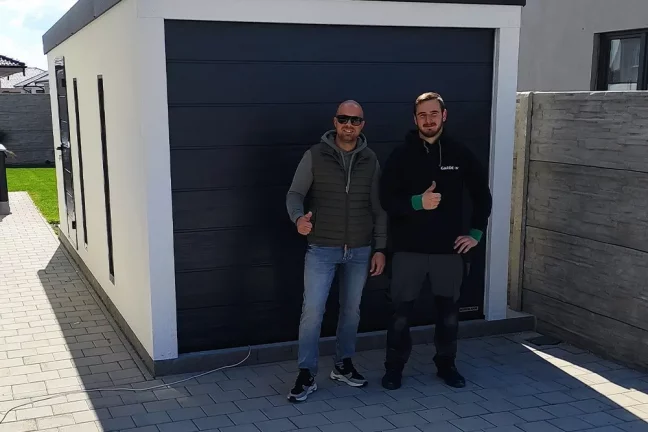 Spokojený zákazník před garáží s montážníkem