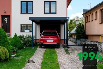 Červené auto pod přístřeškem pro jedno auto