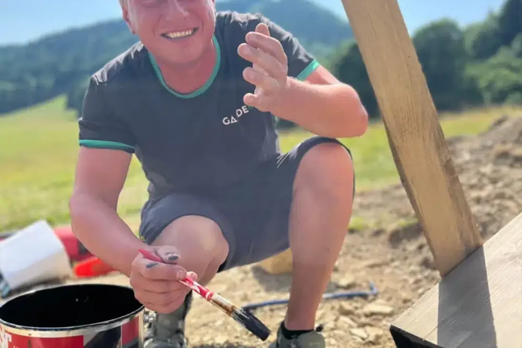 Montážník natírá lavičku.