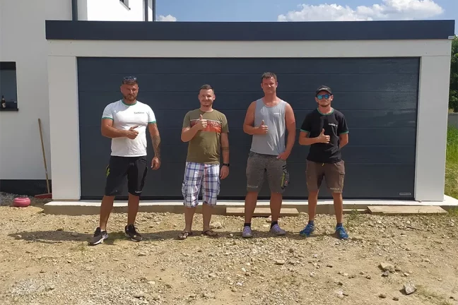 Zákazník s montážníky před garáží