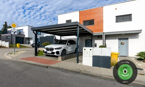 Bíle auto pod přístřeškem v antracite