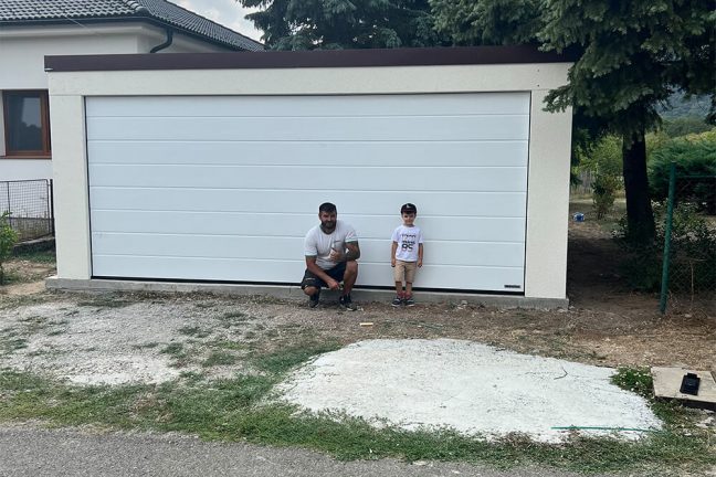 Montážnik s chlepcem před garáží