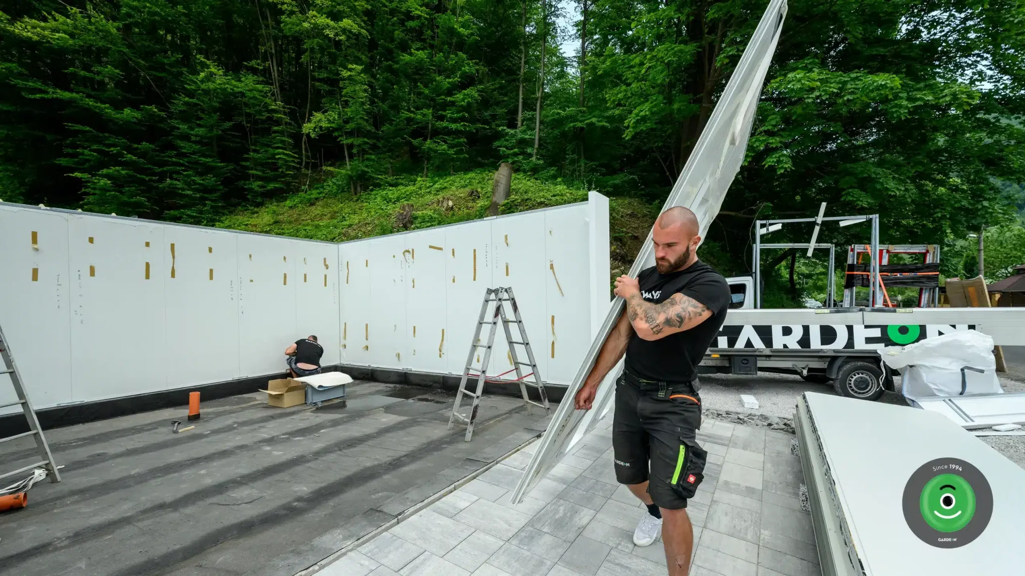 Montážník přináší izolované stěny garáže