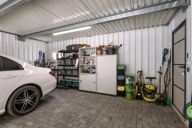 Interiér bílé garáže s montovanými regály a úložným prostorem