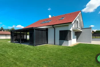 Černá pergola dotýkající se bílého rodinného domu