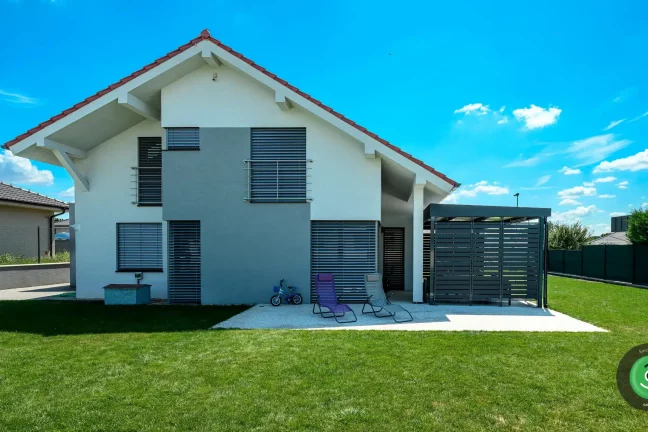 Bílo-šedý rodinný dům s montovanou černou pergolou