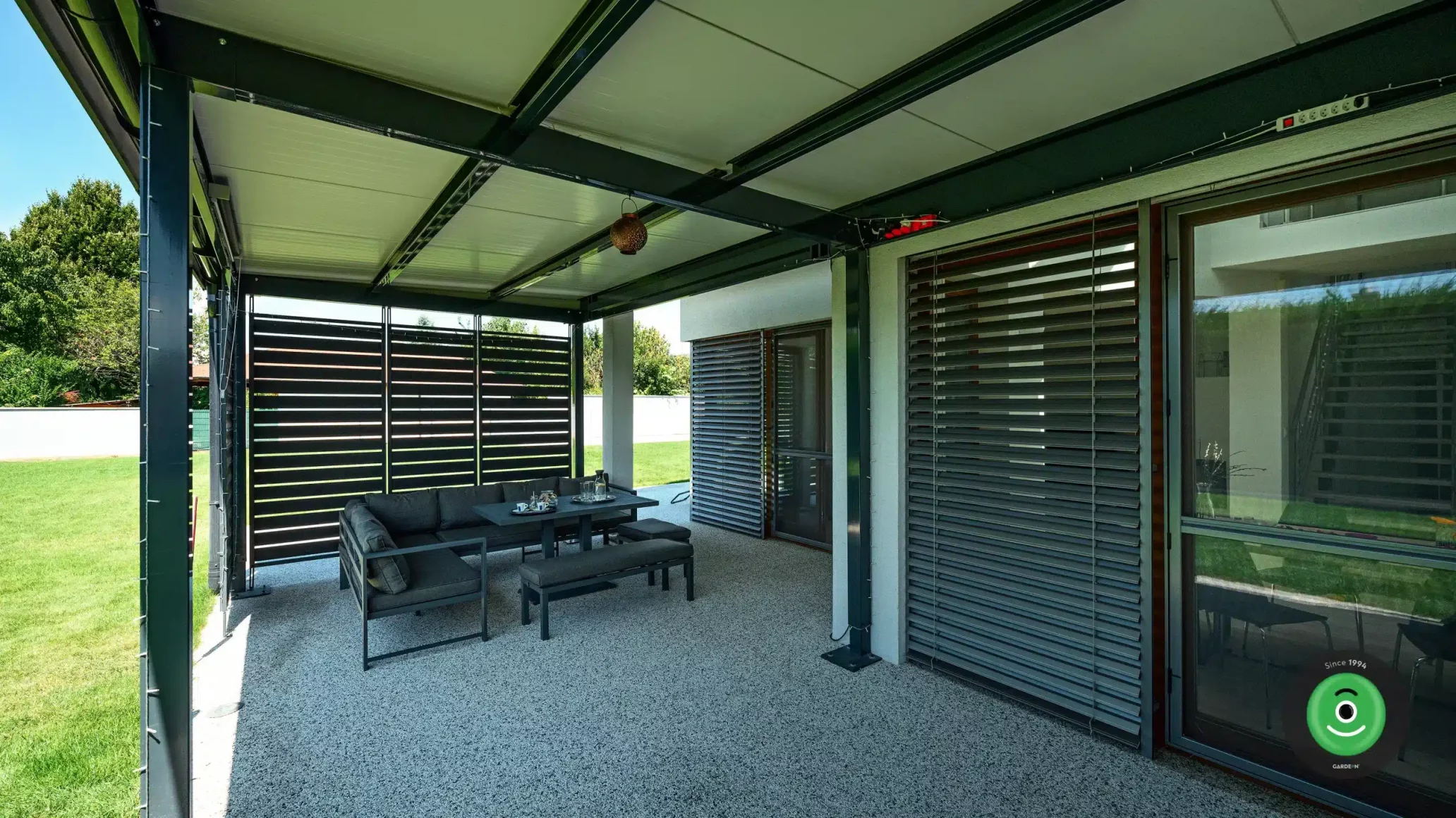 GARDEON pergola opřena o rodinný dům s posezením uvnitř