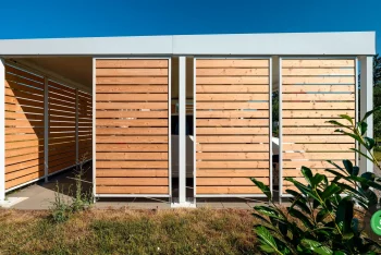 Bílý přístřešek GARDEON s bílým autem uvnitř na zahradě