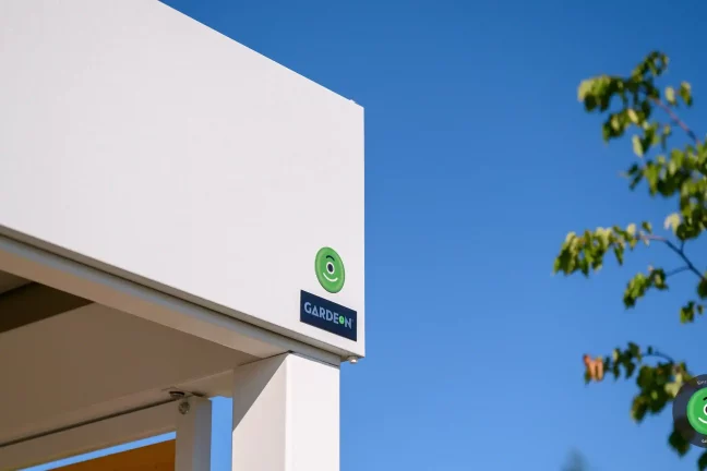 Detail na logo firmy GARDEON umístěný na bílé atice přístřešku