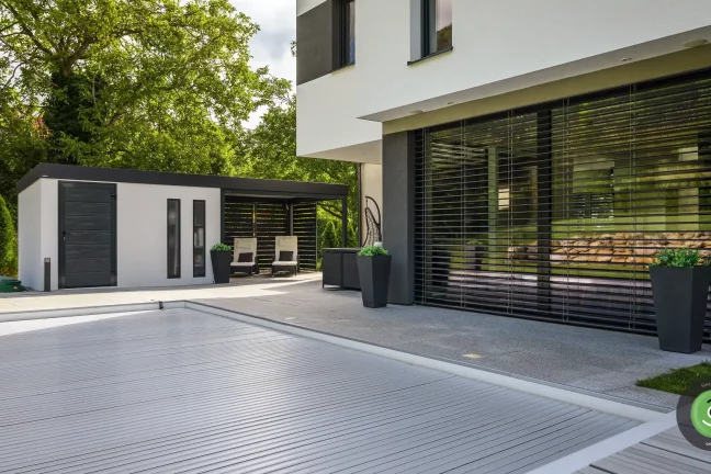 Rodinný dům vedle bílého zahradního domku