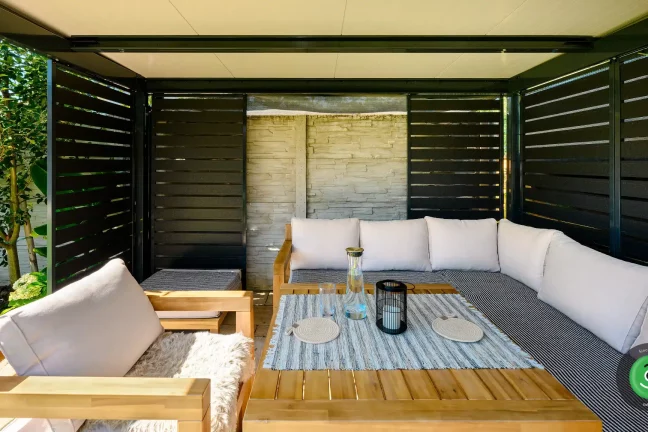 Dřevěné letní posezení s polštáři v pergole