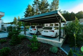 Přístřešek pro dvě auta obklopený zasazenými stromky