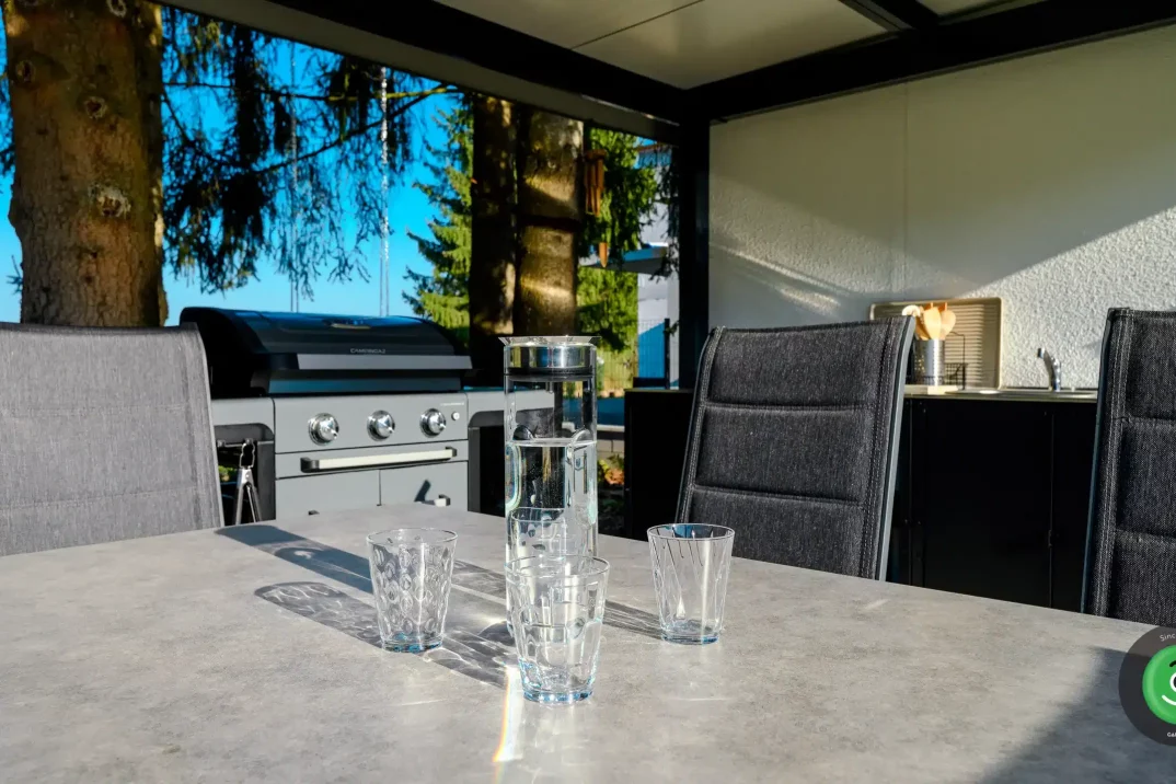 Detail na sklenice s vodou položené na stole v přístřešku