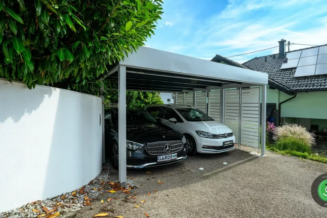 Dvě auta zaparkovaná v bílém přístřešku pro auta GARDEON