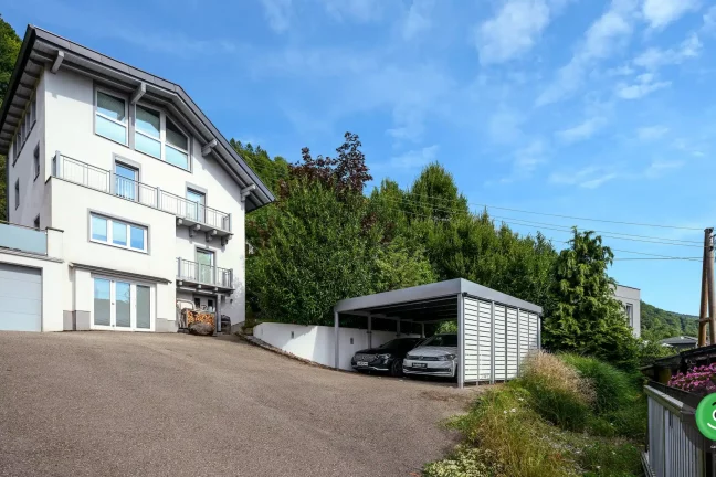 Přístřešek GARDEON vedle velkého bílého rodinného domu