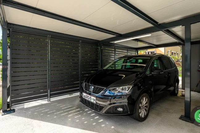 Černé auto v přístřešku s černou kovovou výplní