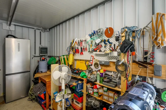 Vnitřek zahradního domku se závěsnými systémy a policemi