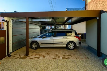 Stříbrné auto pod přístřeškem GARDEON s garážovými vraty