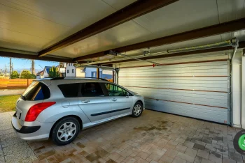 Zaparkované auto pod přístřeškem GARDEON s garážovými vraty