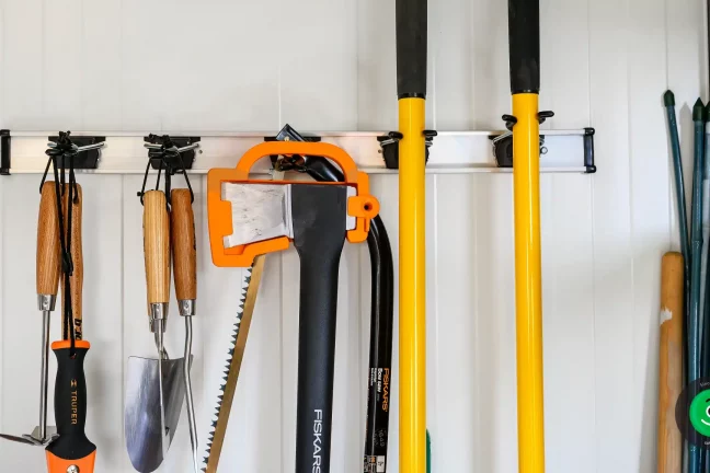 Závěsný systém na nářadí umístěný na stěně zahradního domku