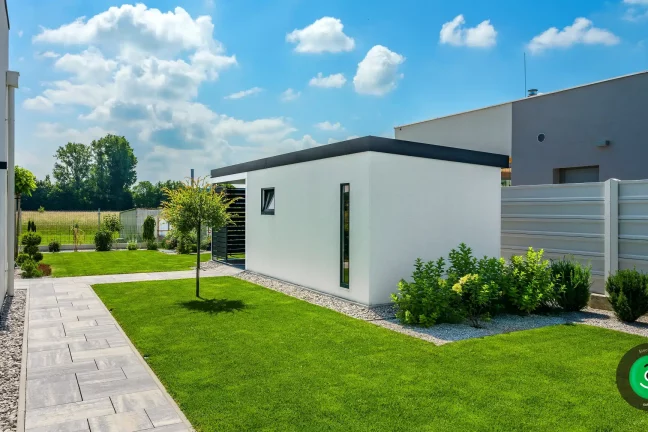 zelená zahrada s bílým zahradním domkem